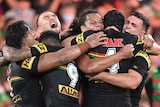 Rugby league players celebrate after winning the grand final