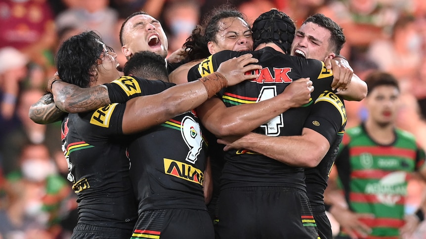 Rugby league players celebrate after winning the grand final