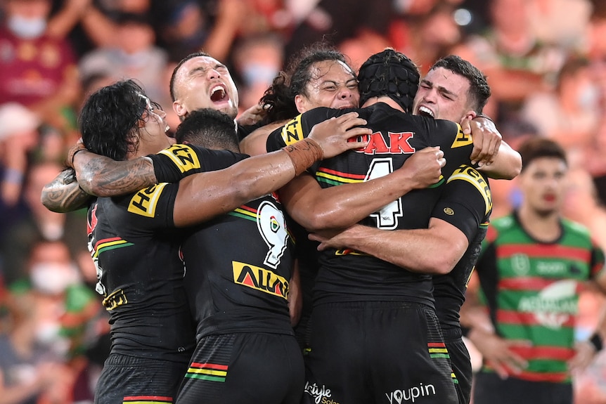 Rugby league players celebrate after winning the grand final