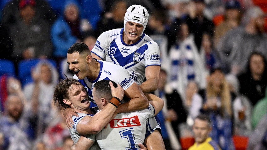 Four players from the Canterbury Bulldogs hug each other after scoring a try