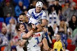 Four players from the Canterbury Bulldogs hug each other after scoring a try