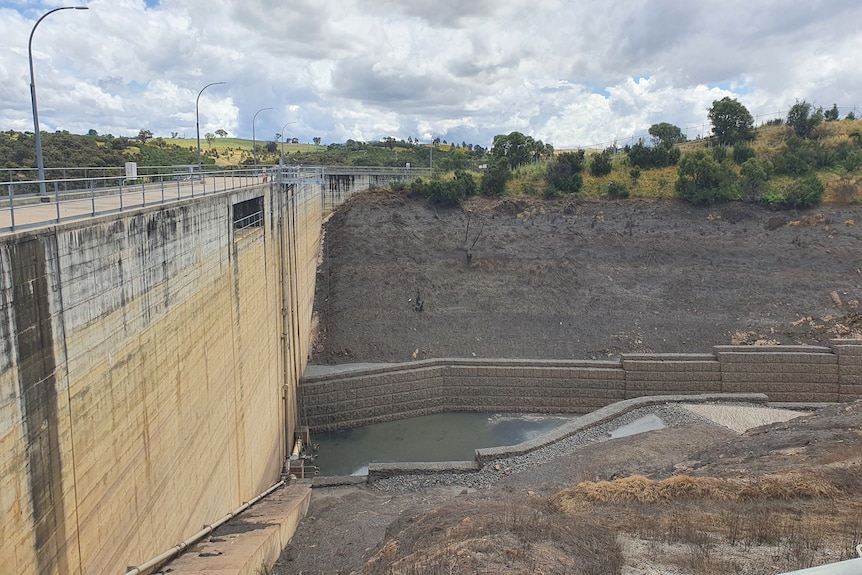 The Molongolo dam mostly empty, with a dark line where the water was previously.