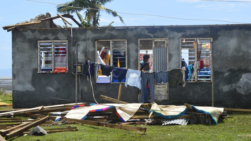 Clothes hang outside a home which has had its roof torn off by Tropical Cyclone Winston in Fiji