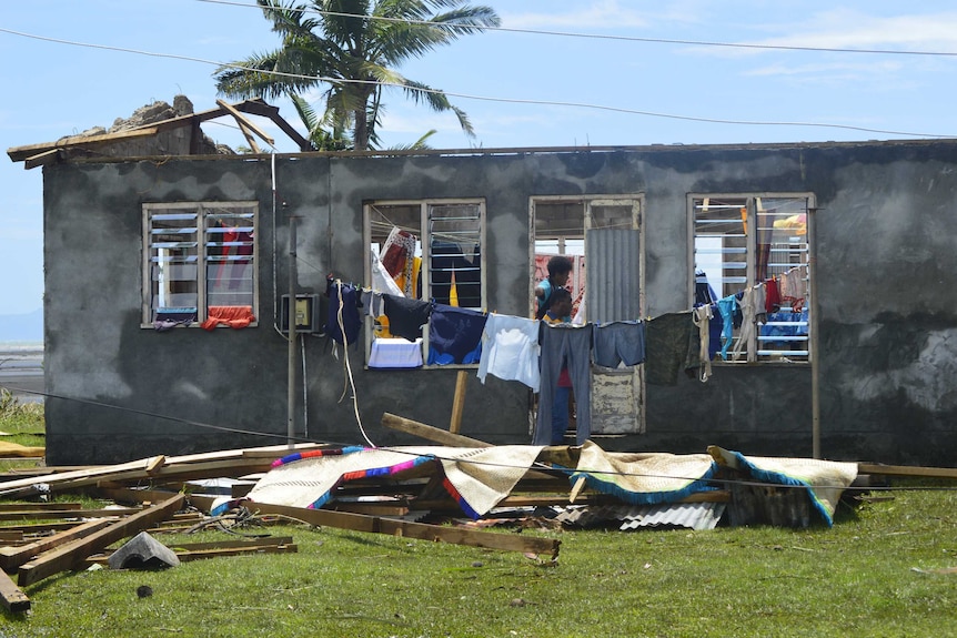 Clothes hang outside a home which has had its roof torn off by Tropical Cyclone Winston in Fiji
