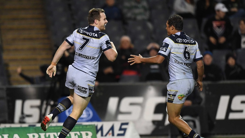 Michael Morgan of the Cowboys (L) celebrates with a teammate after scoring try against Wests Tigers.