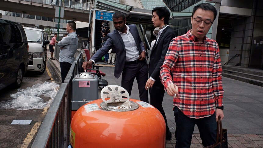 People smoke conventional cigarettes in an outdoor area in Hong Kong.