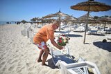 A man places flowers at the beach next to the Imperial Marhaba Hotel in Tunisia where 38 people were killed in a terrorist attack.