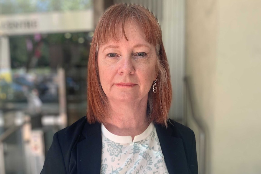 woman with red hair looking into the camera