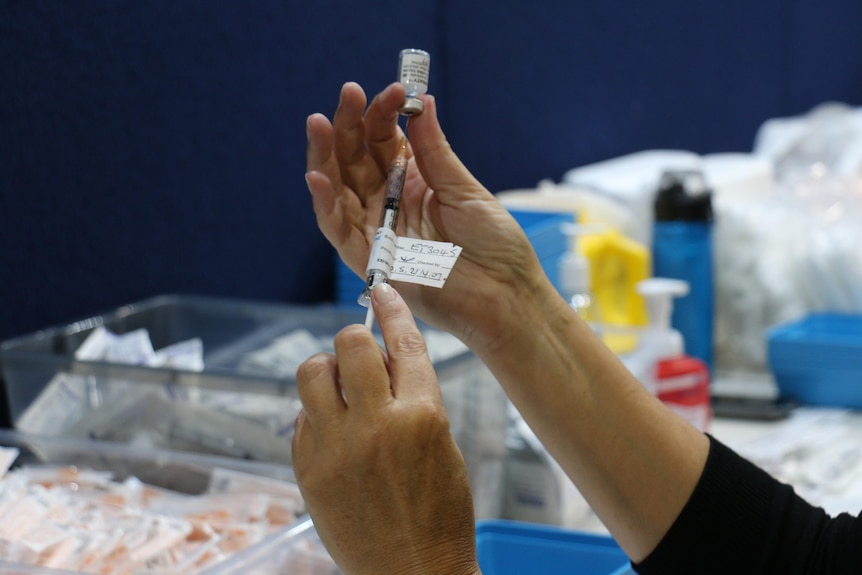 A close up of a Pfizer vaccine shot being prepared