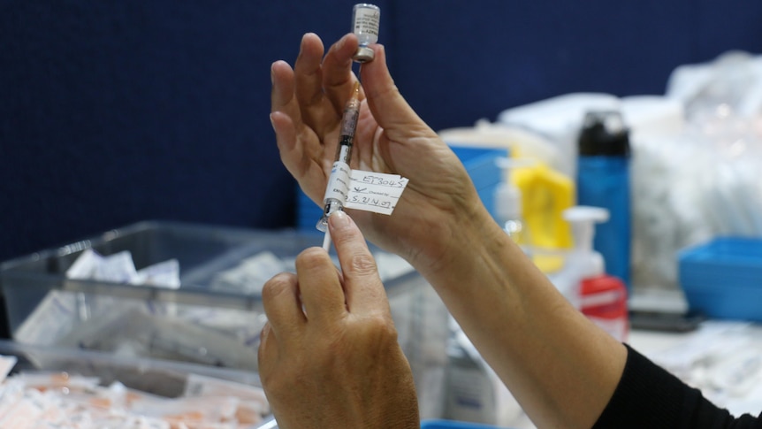 A close up of a Pfizer vaccine shot being prepared