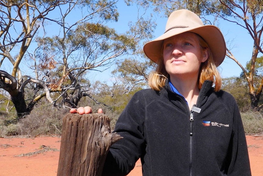 Bush Heritage Australia ecologist and reserve manager Tina Parkhurst standing at an old fence post on Eurardy Nature Reserve.