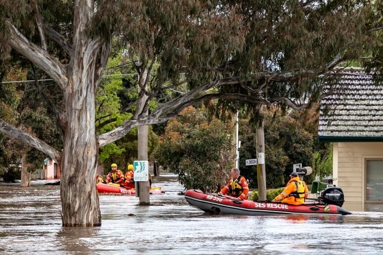 A rescue boat rides through streets that have become rivers.