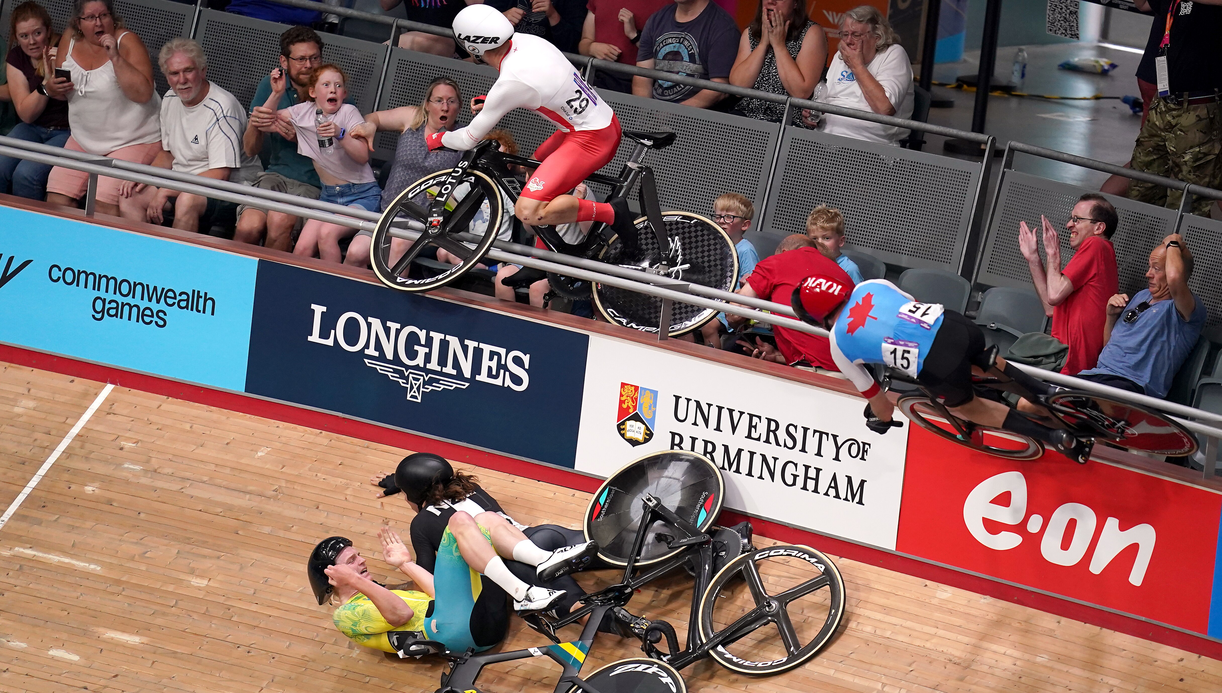 A male track cyclist lands in the crowd with his bike following a crash at the Commonwealth Games.