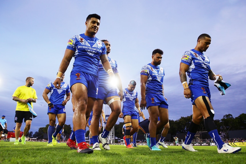 A group of rugby league players leave the field after losing a match