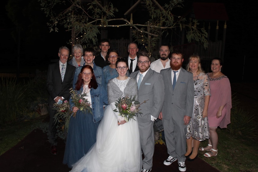 A bride and groom surrounded by wedding guests