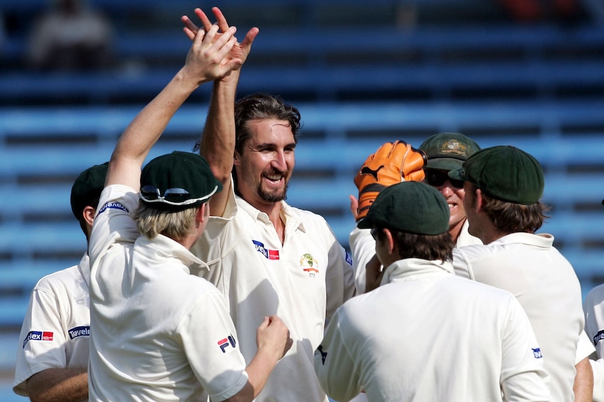 Jason Gillespie smiles and holds up his hand