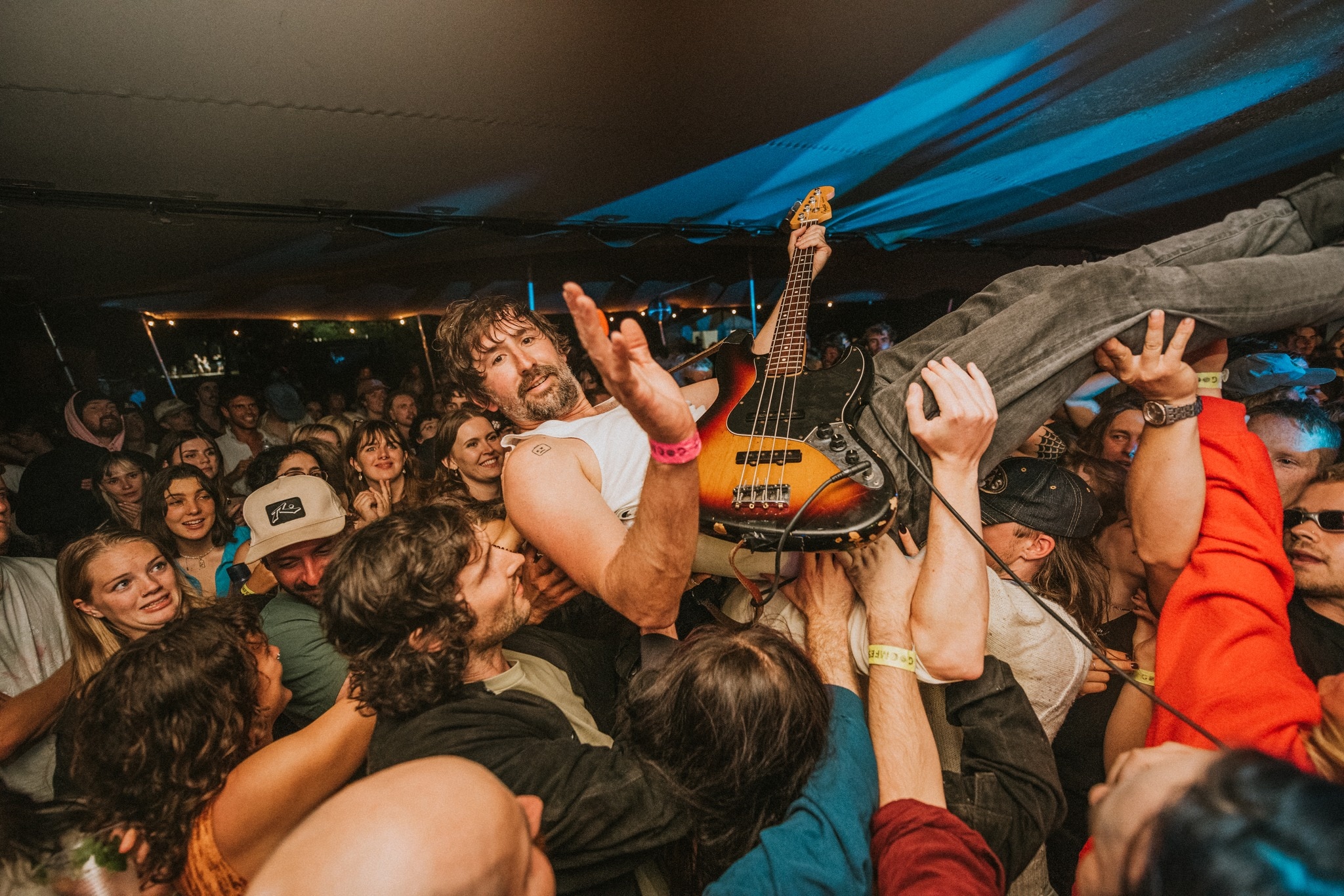 A bass guitarist crowd surfing