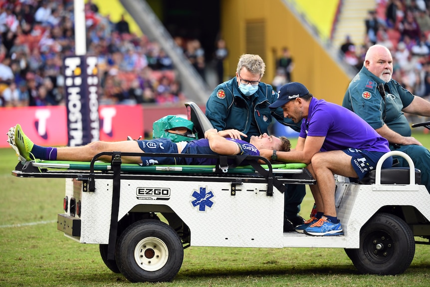 Rugby league player getting stretchered off the field after a head high tackle during a match