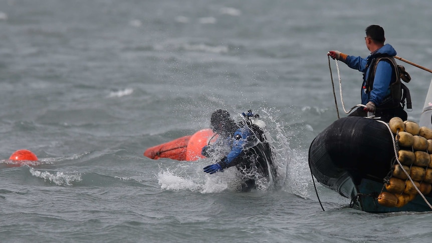 A South Korean diver enters the water near floats where the capsized passenger ship Sewol sank.
