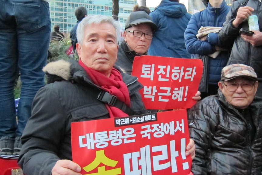 Lee Sung-chun holds a protest sign