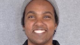 Ahmed Yussuf smiling and wearing a beanie facing the camera