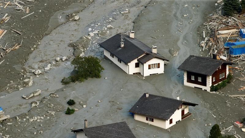 Houses are surrounded by debris of a landslide