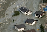 Houses are surrounded by debris of a landslide