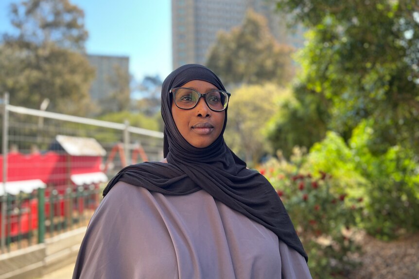A woman wearing glasses and a hijab.