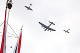 A Lancaster, Spitfire and Hurricane perform a fly past as the Royal Family look on