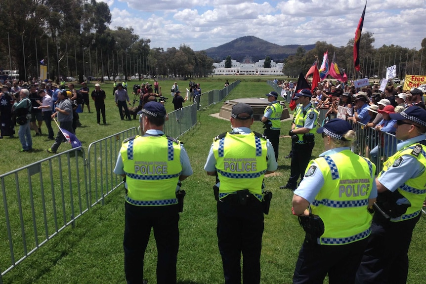Police look towards Old Parliament House as they watch over rival protesters.