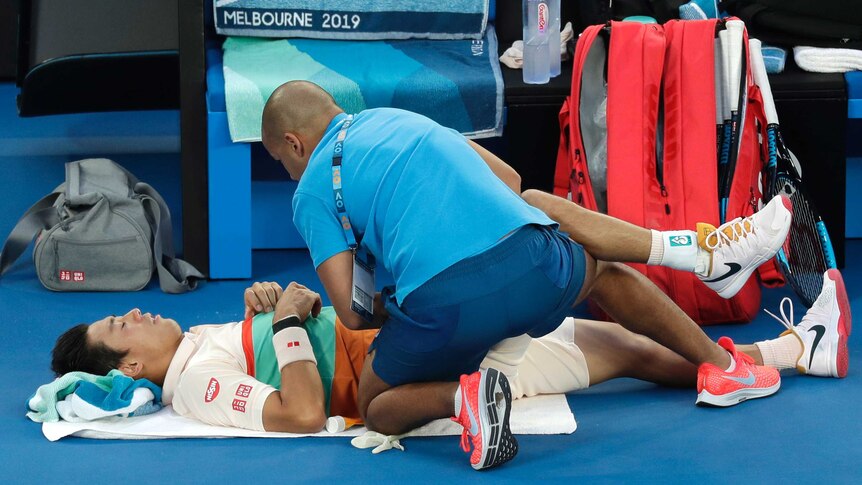 Tennis player receives medical treatment on court at the Australian Open.