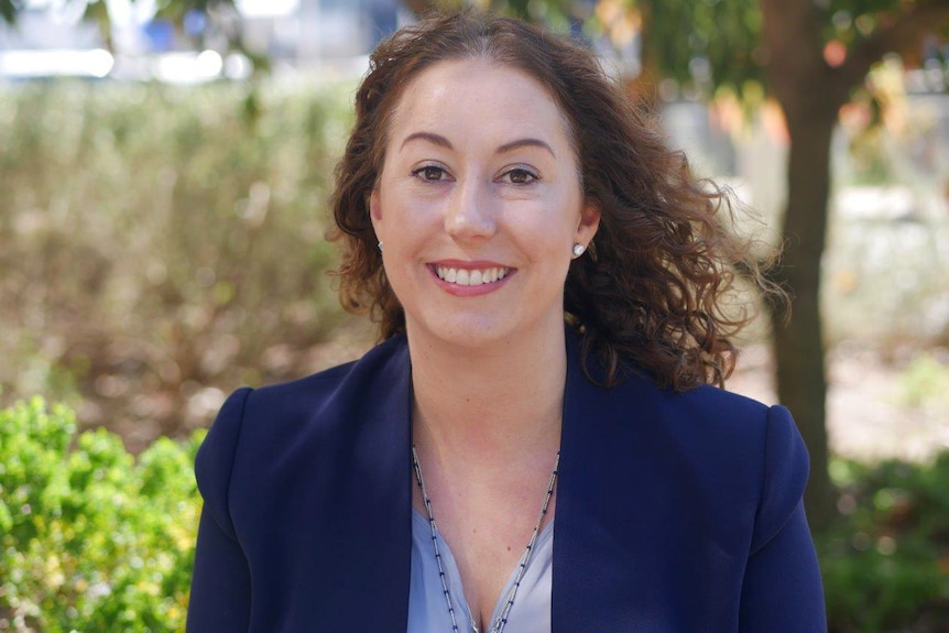 A medium shot of Sam Rowe, Parliamentary Secretary to WA Education Minister, smiling and wearing a blue jacket outdoors.