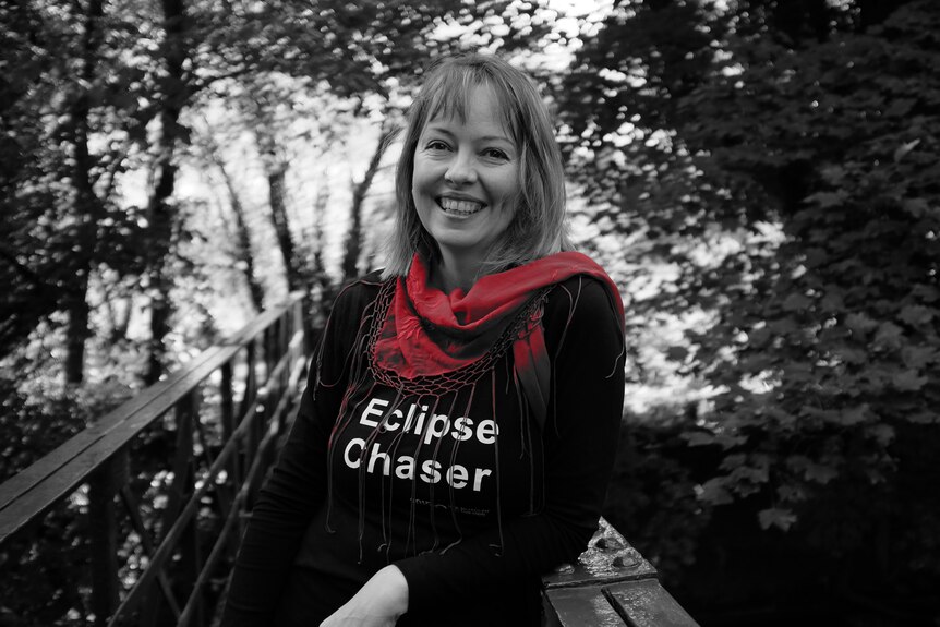 A woman wearing a top with the words "eclipse chaser"