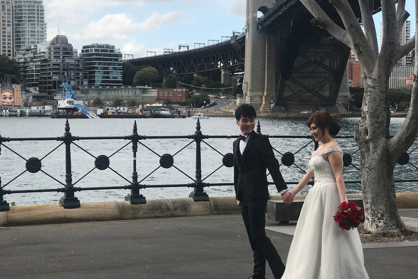 Newlyweds pose in front of fallen crane