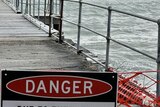 A jetty closed with a 'danger' sign erected at its entry point