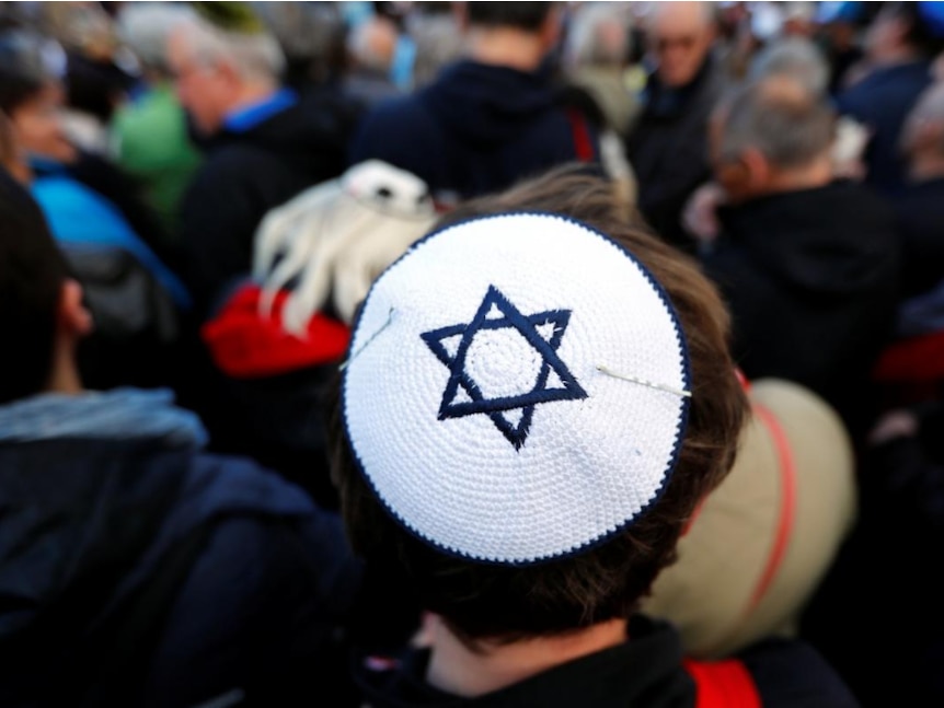 A man wears a kippa during a demonstration.