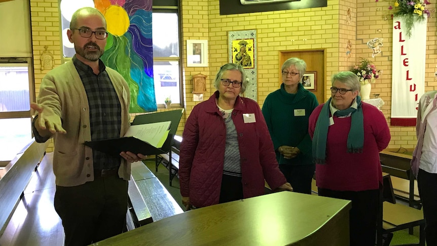 Man teaches parishioners how to conduct a funeral