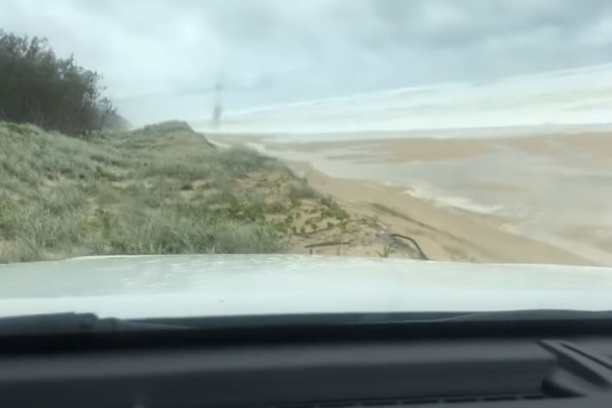 A still image from the video showing a car driving on sand dunes
