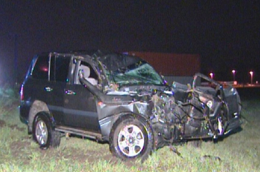 The wreck of a four-wheel drive sits parked on grass after it crashed into a power pole.