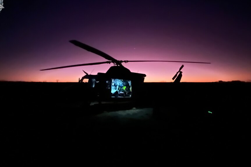 Image of a helicopter silhouetted against the rising sun during the rescue of a man rescued near Sandstone in WA's Mid West