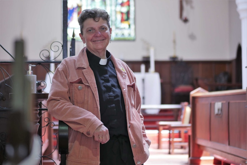A female Anglican priest standing in the middle of St John's Church in Albany, the oldest consecrated church in WA.