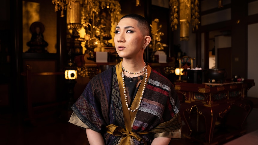 A young Japanese monk with heavy eye make up looking to the heavens. 