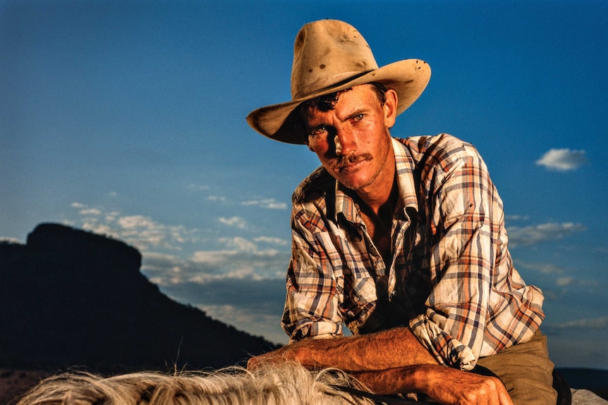 Steve Hawe looks at a camera from atop his horse.