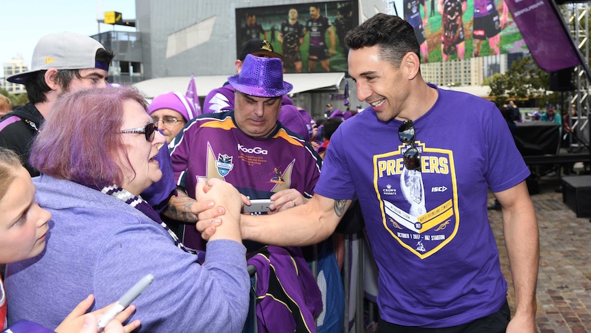Billy Slater, with a big smile on his face, high-fives a Storm fan.