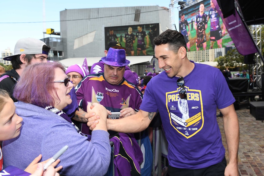 Billy Slater, with a big smile on his face, high-fives a Storm fan.