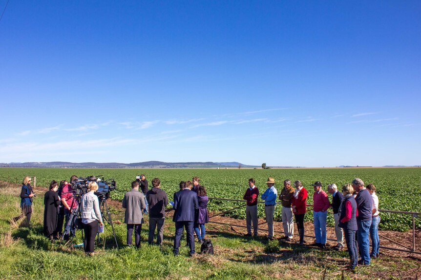 Deputy Premier Troy Grant in a paddock on the Liverpool Plains addressing the media as farmers watch.