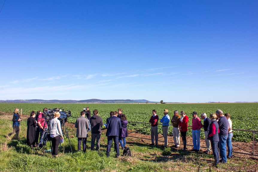 Deputy Premier Troy Grant in a paddock on the Liverpool Plains addressing the media as farmers watch.