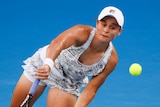Ash Barty sends down a serve on the Australian Open court