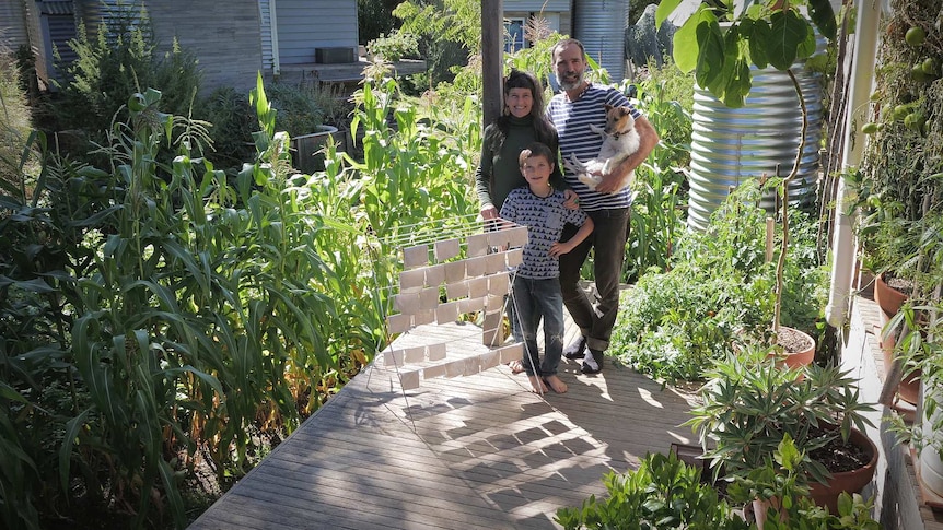 family in their backyard with wee cloths hanging on clothes horse