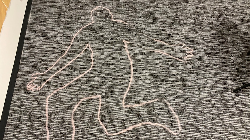 A chalk outline of a body on carpet.